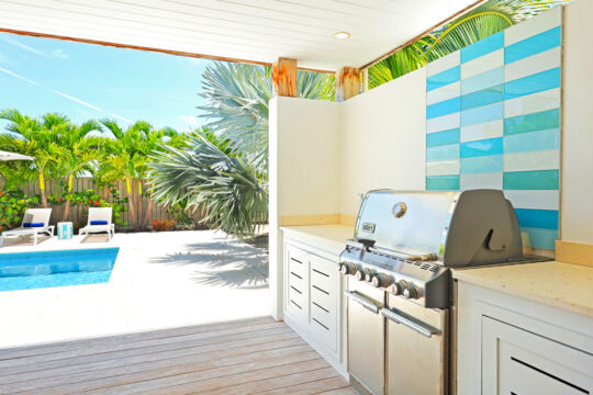 BBQ grilling station at a tropical villa with a pool