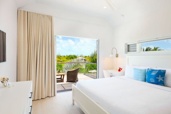 Modern bedroom in a Caribbean villa with a balcony.