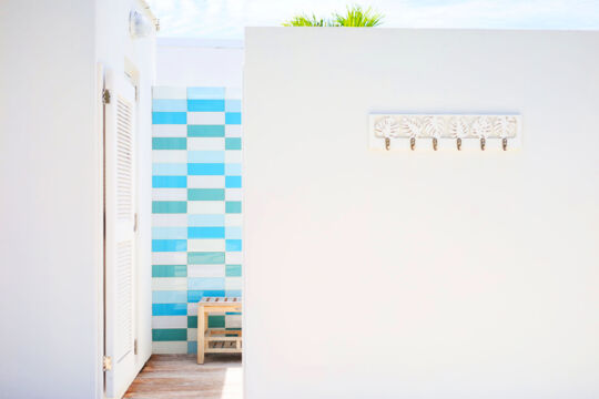Outdoor shower with robe hangers at a modern white villa