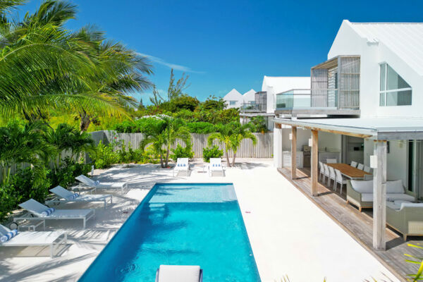 Pool, loungers, and patio of a modern Caribbean villa.