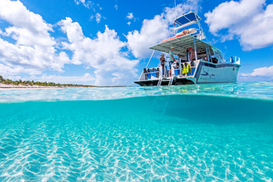 Over-under image of a dive boat in crystal-clear water