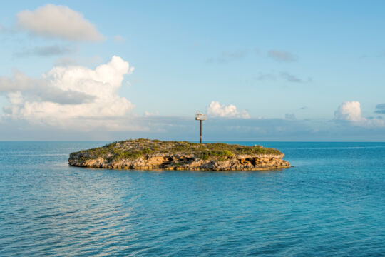 Tiny island with a small light tower in the ocean off Providenciales