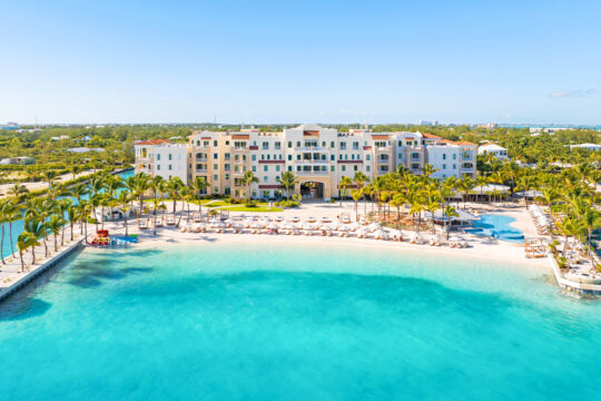 Large resort on a white-sand beach with turquoise ocean water