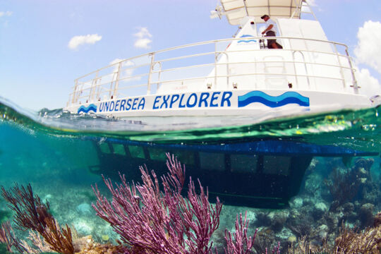Over-under photo of a semi-submarine exploring a coral reef