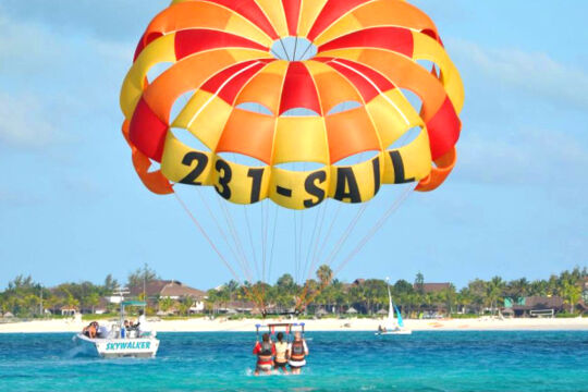 Three people parasailing off Grace Bay Beach in Turks and Caicos