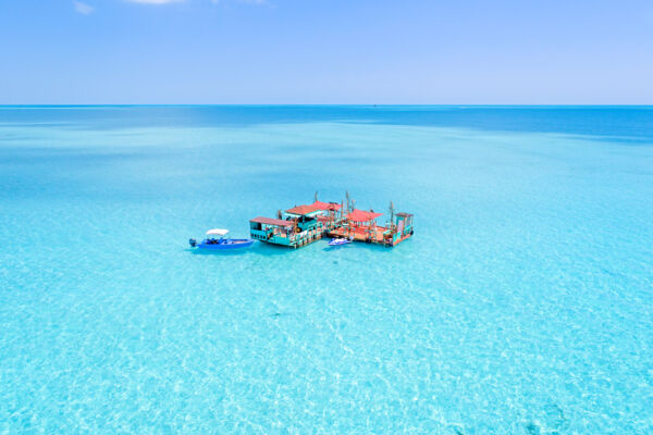 Aerial view of Captain Oak's floating bar on the shallow waters of the Caicos Banks