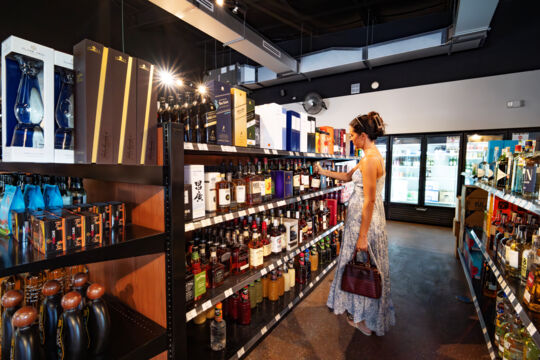Woman shopping for spirits at a liquor store. 
