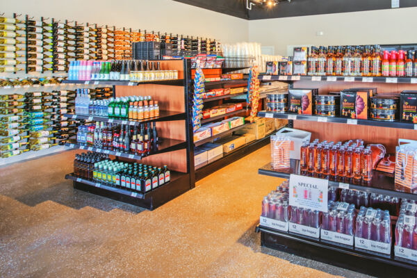 Various alcohol products displayed on a shelf inside a liquor store. 