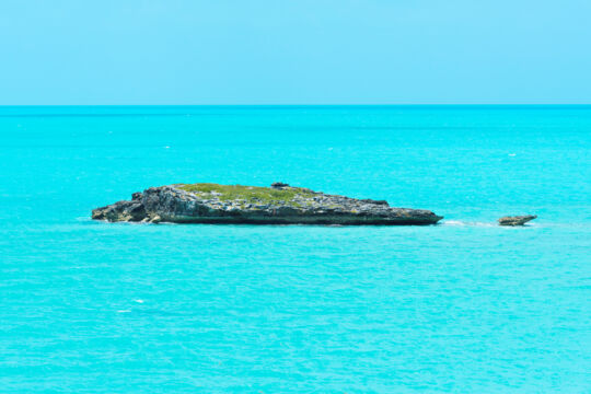Small rocky island in turquoise ocean