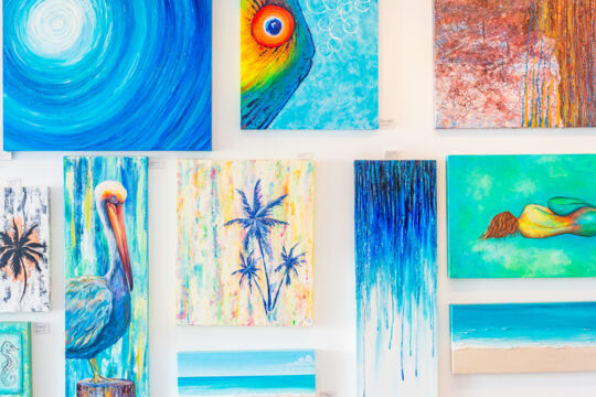 Colorful paintings of tropical animals and scenes at a gallery