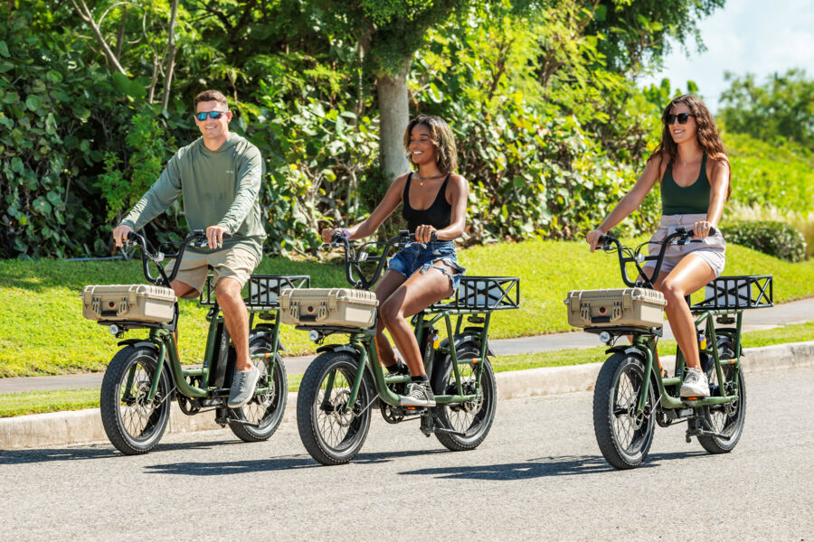 Three people riding electric bikes on the road in Turks and Caicos.