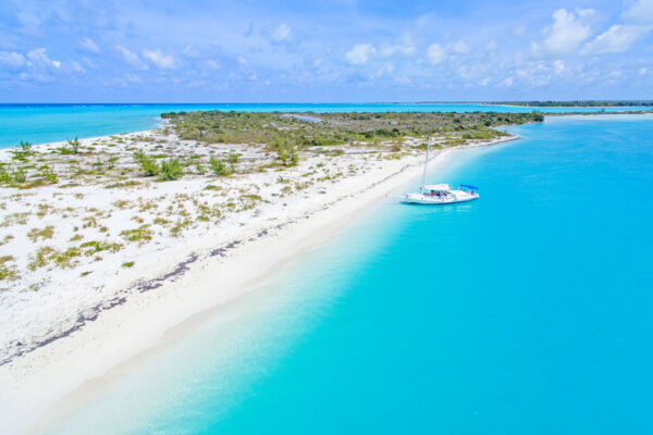 The beautiful beach and charter tour sailboat at Fort George Cay in the Turks and Caicos.
