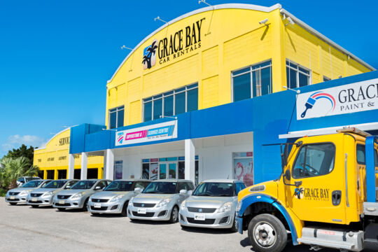 Rental cars parked outside the large Grace Bay Car Rental office on Leeward Highway