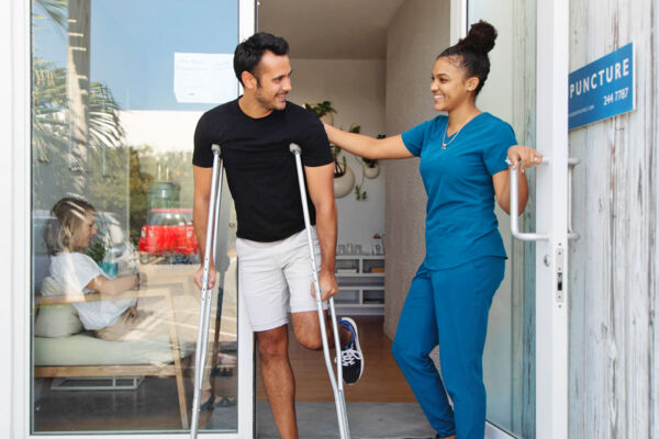 Man on crutches at a medical clinic.