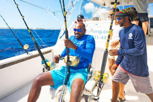 Man reeling in a fish on a deep-sea fishing charter. 