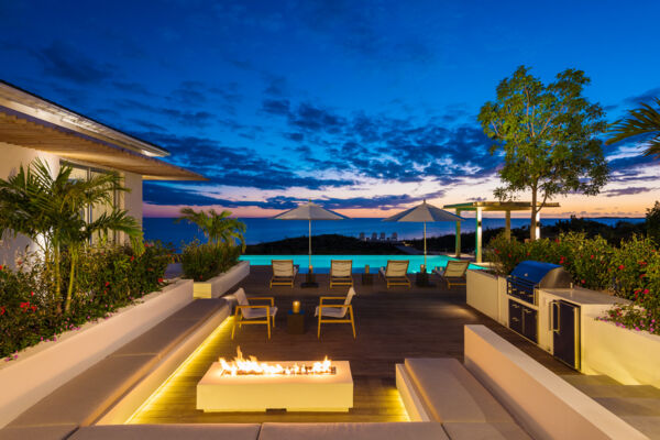 Outdoor lounging space and pool at dusk