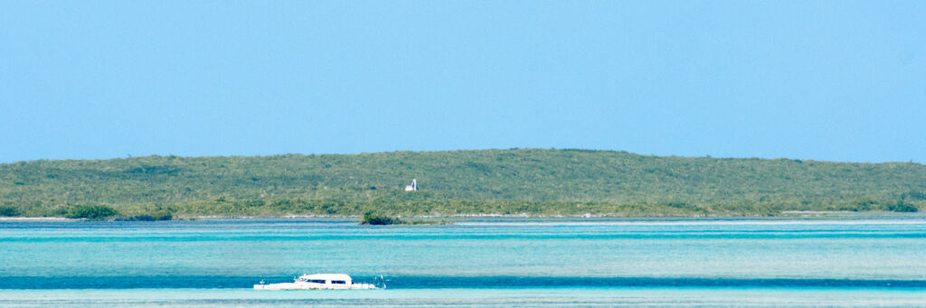 Catamaran wreck and ruins on the horizon of Hog Cay