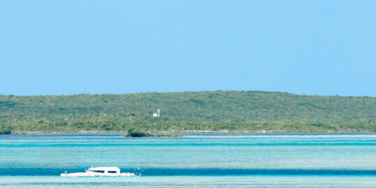 Catamaran wreck and ruins on the horizon of Hog Cay