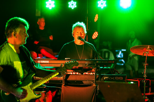 Keyboard player performing with a band at night
