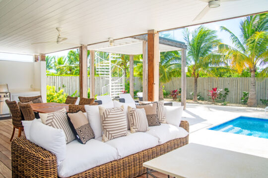 Covered pool deck with dining table and BBQ