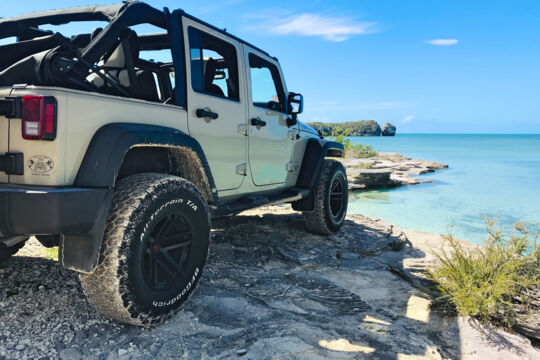 Beige Jeep Wrangler parked by the ocean at West Harbour Bluff in Turks and Caicos