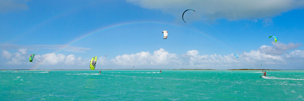 Rainbow and kiteboarders on the shallow turquoise waters of the Caicos Banks