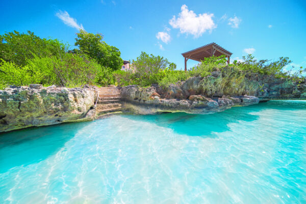 Rock stairs leading into turquoise water. 