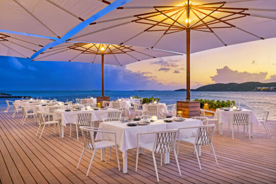 Waterfront restaurant on a dock with a beautiful sunset.