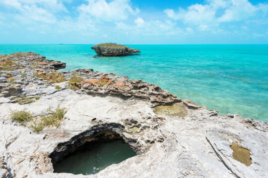 Small rocky island in crystal-clear water