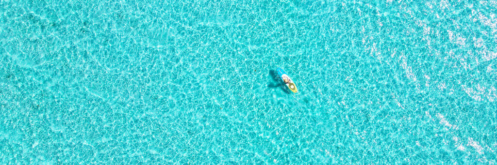 Paddle boarder on the shallow turquoise ocean in the Turks and Caicos
