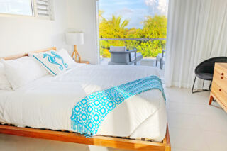 Bright tropical villa bedroom with a private balcony