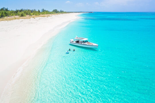 Boat charter visiting a remote beach with turquoise water in Turks and Caicos