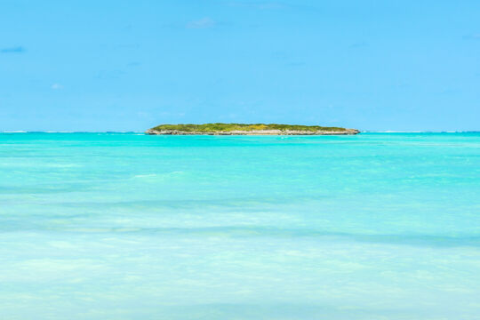 Small island of Pelican Cay and turquoise ocean
