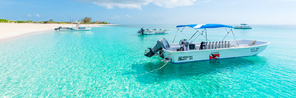 The calm ocean and boat at Pillory Beach fronting the Bohio Dive Resort