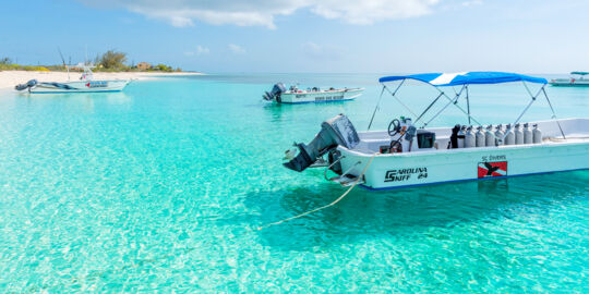 The calm ocean and boat at Pillory Beach fronting the Bohio Dive Resort