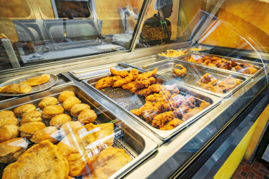 The fast food counter with fried chicken, patties, biscuits, and fish at Pizza Pizza.