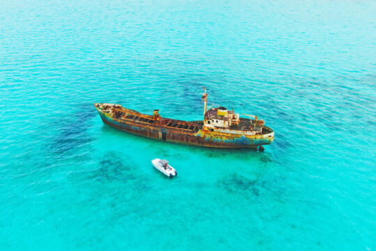 Boat anchored near a large grounded shipwreck in Turks and Caicos. 
