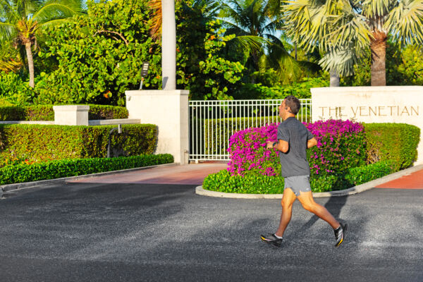 Man running in front of a landscaped resort in Turks and Caicos. 