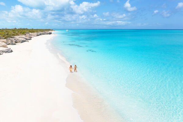 Aerial view of couple walking on the beach at Water Cay in the Turks and Caicos