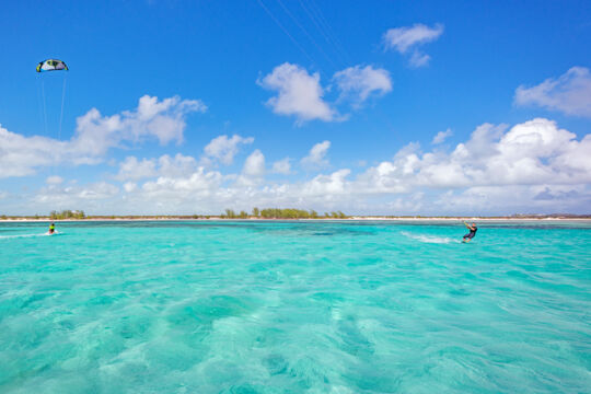 Kiteboarders on turquoise ocean water