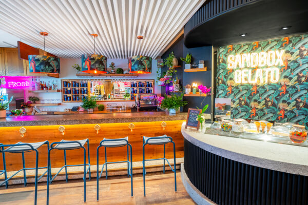 Bright and colorful indoor bar with neon signs and a gelato counter