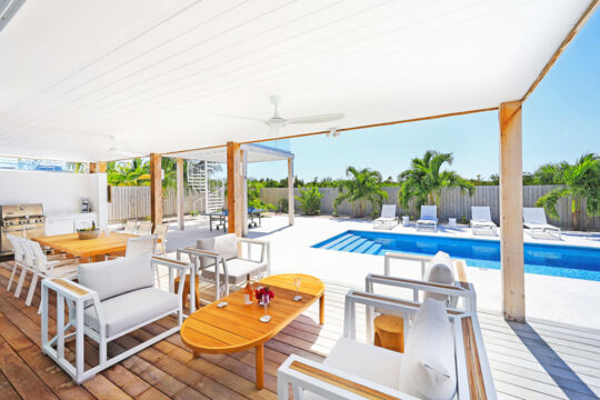 Pool deck with covered outdoor dining area and lounge furniture