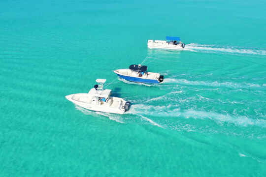 Drone image of three boats cruising in perfect turquoise water