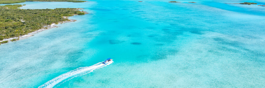 Aerial photo of a tour boat exploring the south coast of Half Moon Bay, Turks and Caicos. 