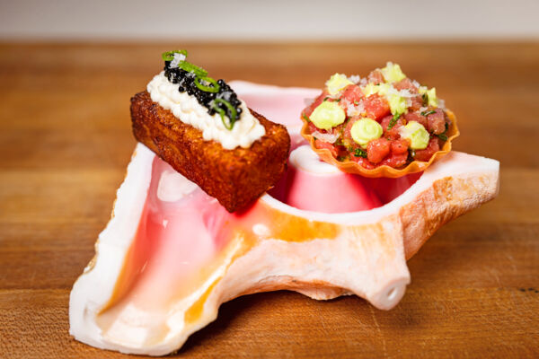 Tuna tartare and shrimp croquette on a conch shell dish.