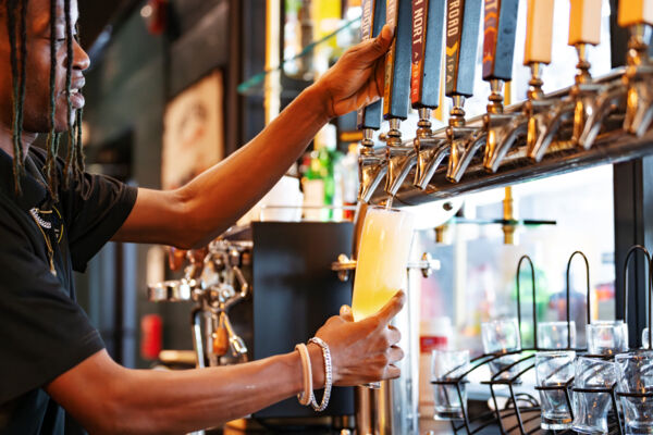 Bartender pouring a tall pint of beer