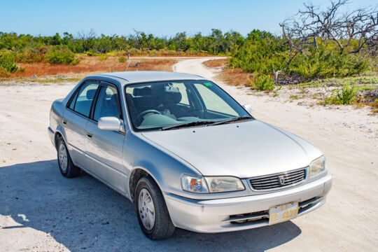 Silver sedan rental car parked on a dirt road