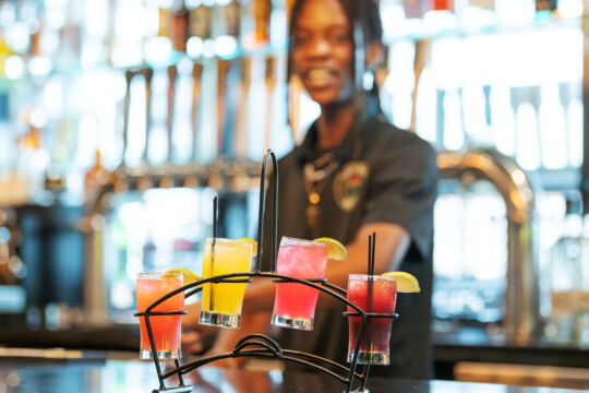 Bartender serving a flight of margaritas