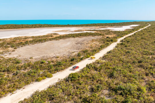 Aerial image of Jeeps driving along an unpaved road on Providenciales, Turks and Caicos. 