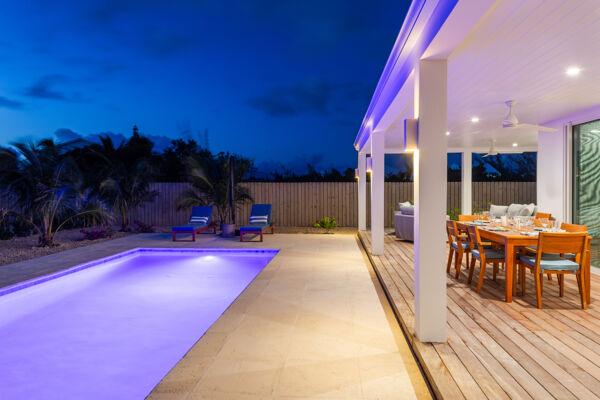 Dining table on a terrace next to a pool